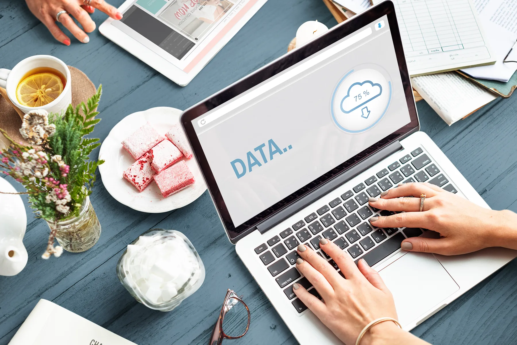 Laptop screen showing cloud data loading while working at a desk