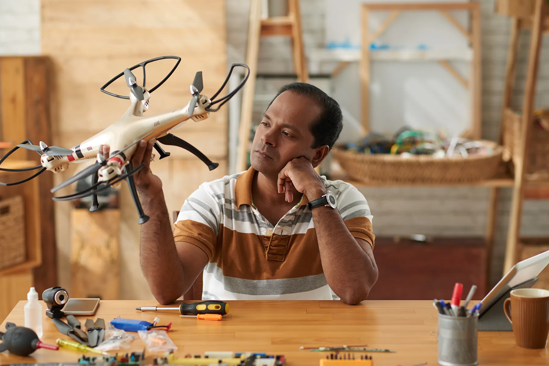 Man examining a drone in a workshop environment